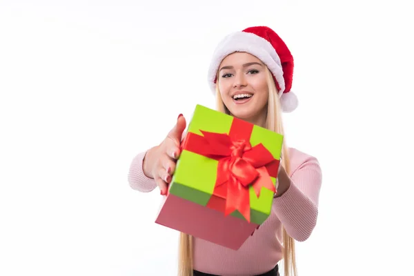 Weihnachtsfrau hält Geschenke aufgeregt in der Hand. glücklich lächelnde Frau mit Weihnachtsmütze, die Ihnen ein Geschenk macht, das fröhlich, frisch und fröhlich ist. — Stockfoto