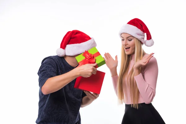 Mutlu Noel ile genç bir çift beyaz arka plan üzerinde mevcut. Kadın Noel arifesi için adam açık hediye. — Stok fotoğraf