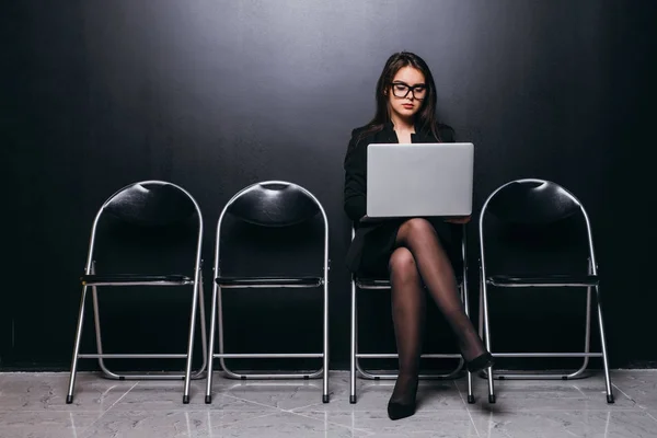 Mulher de negócios focada trabalhando no laptop enquanto espera pela entrevista sentada na cadeira — Fotografia de Stock