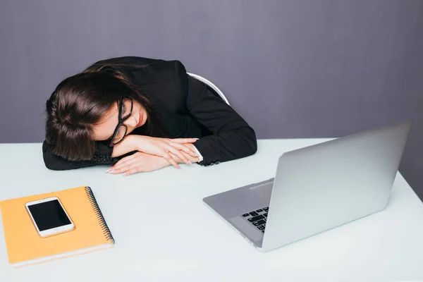 Trött vacker affärskvinna som sover på hennes skrivbord i hennes kontor. — Stockfoto