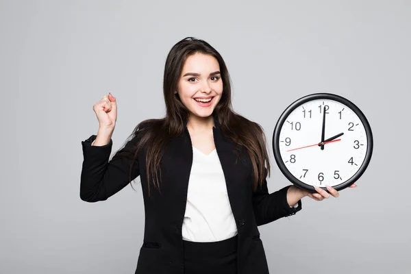 Happu eccitata donna d'affari in giacca e cravatta che tiene l'orologio in mano isolato sfondo grigio — Foto Stock