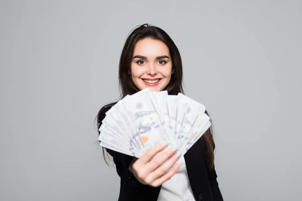 मुस्कुराते हुए व्यवसायी महिला ग्रे पृष्ठभूमि पर पैसे पकड़े हुए — स्टॉक फ़ोटो, इमेज