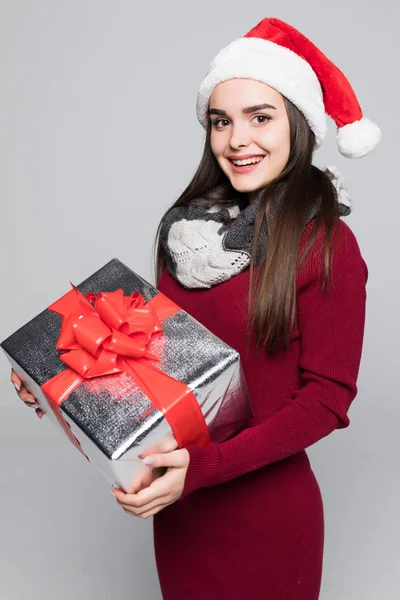 Aufgeregt überrascht Frau in rotem Weihnachtsmann-Outfit mit Stapel Geschenke isoliert auf dem grauen Hintergrund — Stockfoto