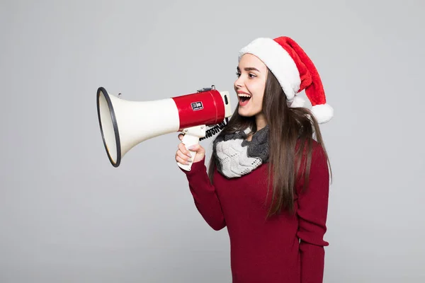 Opgewonden vrouw in KERSTMUTS bedrijf megafoon over grijze achtergrond — Stockfoto