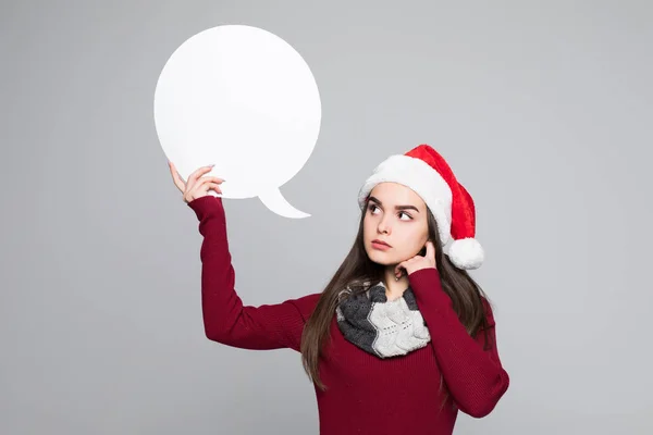 Noel Baba şapkası ile konuşma balonları gri arka plan üzerinde genç güzel kadın — Stok fotoğraf