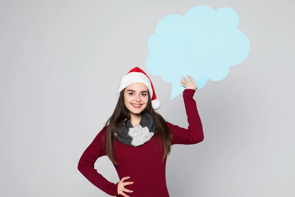 Молода красива жінка в капелюсі Санта з бульбашками мовлення на сірому фоні — стокове фото