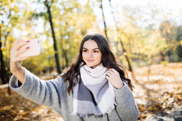 Junges Mädchen macht ein Selfie im hinteren Herbstpark — Stockfoto
