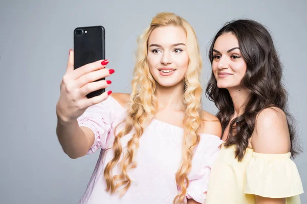 Portréja egy boldog két mosolygó lány, hogy selfie fénykép smartphone fehér háttér — Stock Fotó