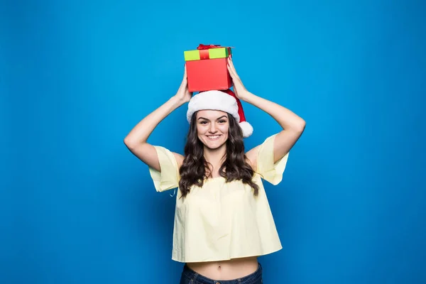 Kerstmis, vakantie, feest en mensen concept - lachende vrouw in rode jurk met geschenkdozen op blauwe achtergrond — Stockfoto