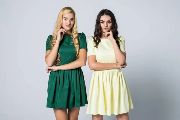 Portret dwóch atrakcyjnej blondynki i Brunetki młode kobiety w sukienki, patrząc na kamery, pozowanie na biały bacgkound — Zdjęcie stockowe