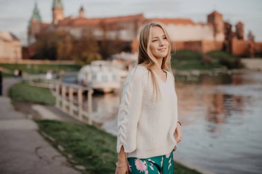 Güzel genç sarışın Nehri yakınında setin yürüyorduk ve yaz aylarında gün batımında poz