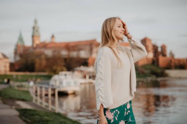 Güzel genç sarışın Nehri yakınında setin yürüyorduk ve yaz aylarında gün batımında poz