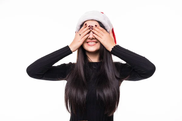 Detail tváře portrét usmívající se žena s rukama zavřené oči, nosit zimní klobouk santa zavřít oči a čeká dárek na bílém pozadí — Stock fotografie