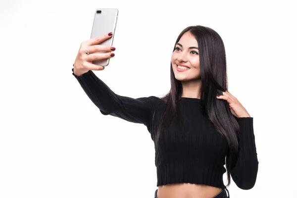 Mulher bonita está fazendo foto selfie com smartphone no fundo branco — Fotografia de Stock