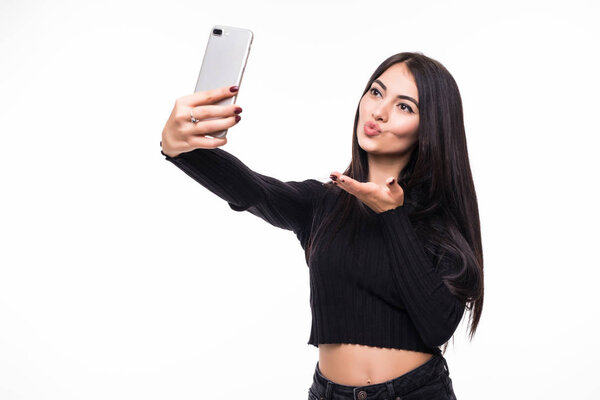 Pretty young happy woman making selfie on smartphone on white background