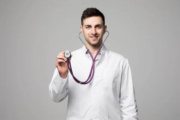 Uśmiechnięty Doktor przytrzymanie stetoskop i słuchając bicia serca na białym tle — Zdjęcie stockowe