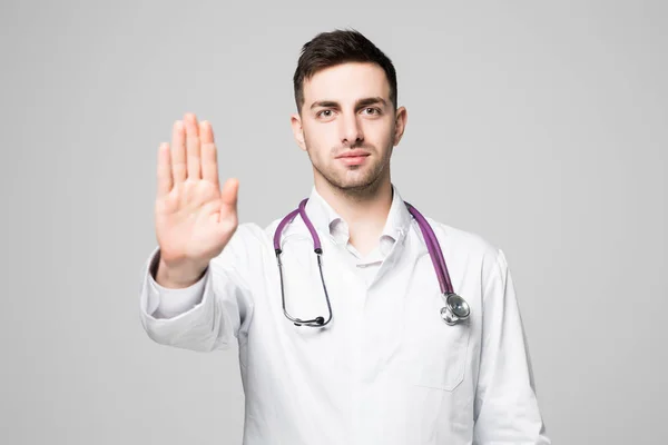 Lekarz z stetoskop pokazać stop lub znak nie dozwolonych przez rękę na białym tle. — Zdjęcie stockowe