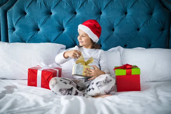 Hediyeler Noel sabahı yatakta Noel Baba'nın açılış çok komik çocuk kız — Stok fotoğraf