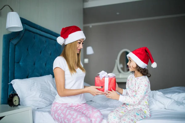 Noel sabahı yatakta hediyeler vererek mutlu aile anne ve çocuk kızı — Stok fotoğraf