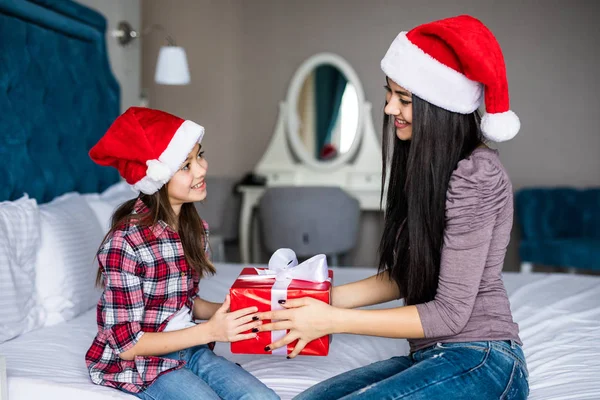 Lycklig familj mamma och barn dotter delar och att ge gåvor i sängen på juldagsmorgonen — Stockfoto