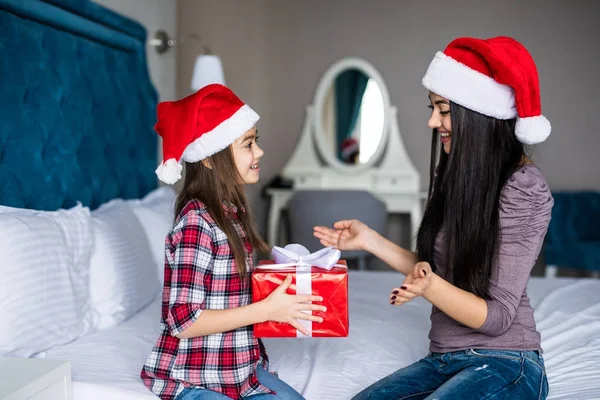Anne küçük şirin kız yatakta sabah gülümseme ile Noel hediye al — Stok fotoğraf