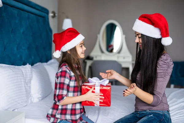 Anne küçük şirin kız yatakta sabah gülümseme ile Noel hediye al — Stok fotoğraf