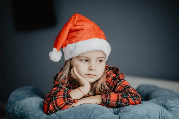 Portresi oldukça üstünde belgili tanımlık pencere evde arıyorsunuz Noel Baba için bekleyen Noel Baba şapkası, küçük kız hamile. Noel arifesi. — Stok fotoğraf