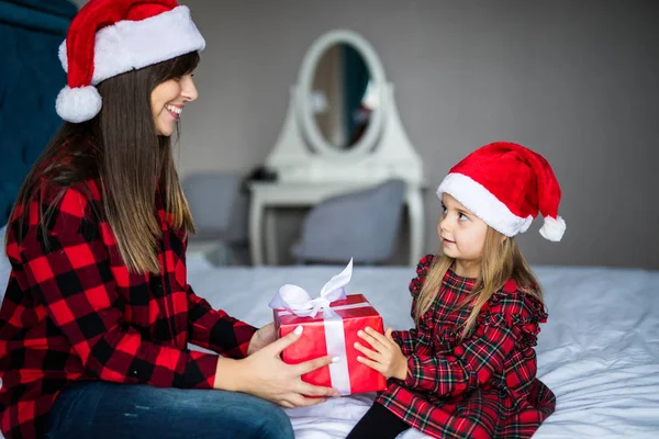 Noel sabahı yatakta hediyeler vererek mutlu aile anne ve çocuk kızı. Anne ve kızı Noel hediyesi açın. — Stok fotoğraf