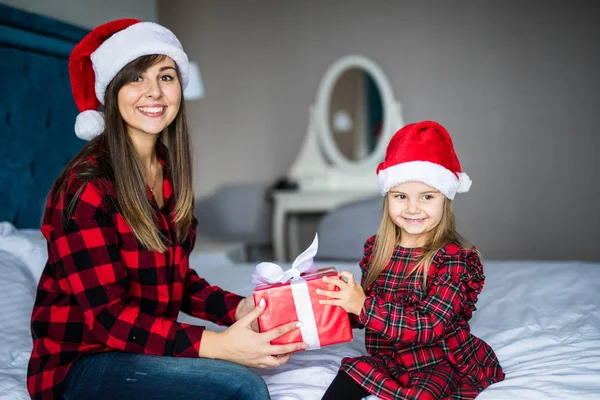 Noel sabahı yatakta hediyeler vererek mutlu aile anne ve çocuk kızı. Anne ve kızı Santa mevcut ve kamera seyir açın. — Stok fotoğraf
