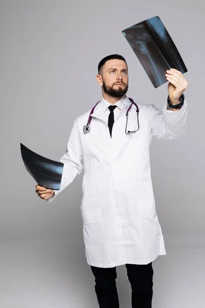 Csinos orvos ember vizsgálata egy röntgen, elszigetelt fehér background — Stock Fotó