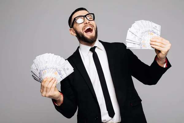 Křičící muž v oficiální barvu drží peníze peníze stojí izolované nad šedá stěna pozadí. — Stock fotografie