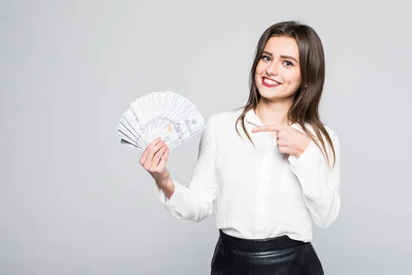 Wizerunek szczęśliwy młoda kobieta stojąc na białym tle nad białym tle trzymając pieniądze wskazując. — Zdjęcie stockowe