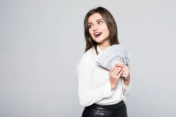 Porträtt av en leende ung kvinna hålla kontanter dollar stående på vit — Stockfoto
