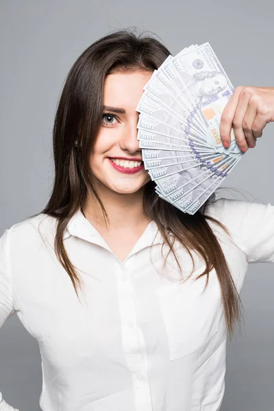 Retrato de cerca de una atractiva mujer sonriente mostrando un montón de billetes de dinero sobre fondo blanco — Foto de Stock