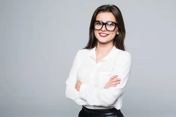 Sorridente donna d'affari con le braccia incrociate in piedi contro sfondo grigio isolato . — Foto Stock