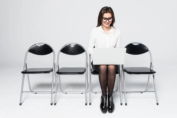 Fiatal mosolyogva office munkavállaló nő ül a fa padló szék mobil laptop számítógéppel interjú értekezlet fájl elszigetelt fehér előkészítése — Stock Fotó