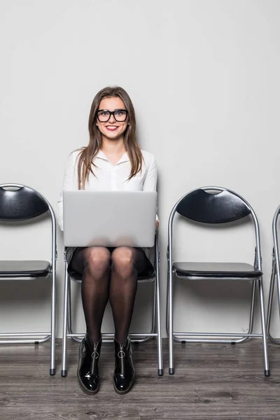 Joven mujer trabajadora de oficina sonriente sentada en la silla del piso de madera utilizando el ordenador portátil móvil preparar la entrevista archivo de reunión en la sala de oficina — Foto de Stock