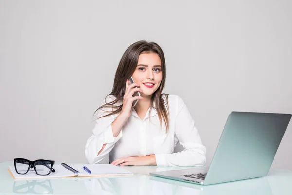 Retrato de la mujer financiera ejecutiva sentada en el escritorio y trabajando en el ordenador portátil mientras hace una llamada en la oficina — Foto de Stock