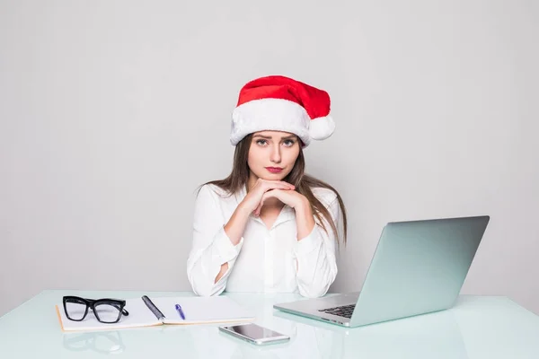 Jovem mulher bonita vestindo um chapéu de Natal trabalhando no escritório — Fotografia de Stock