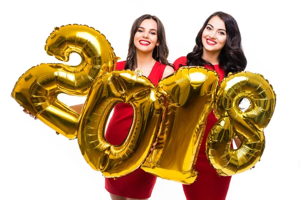 Portret dwóch wesoły szczęśliwy dziewcząt w czerwone sukienki z złoto kolorowe balony numer na białym tle nad białym tle, Nowy Rok 2018. — Zdjęcie stockowe