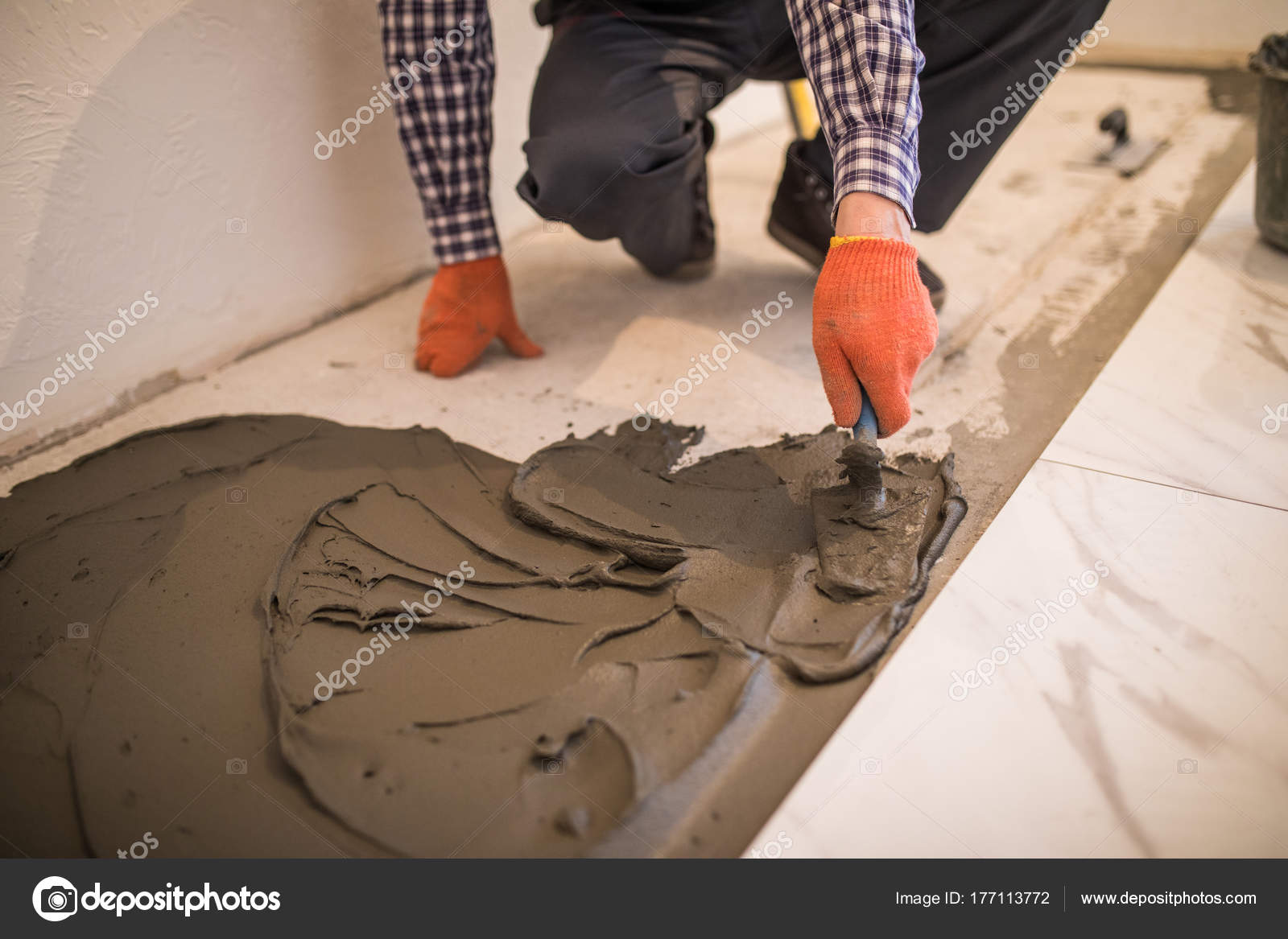 Laying Ceramic Tiles Troweling Mortar Onto A Concrete Floor In