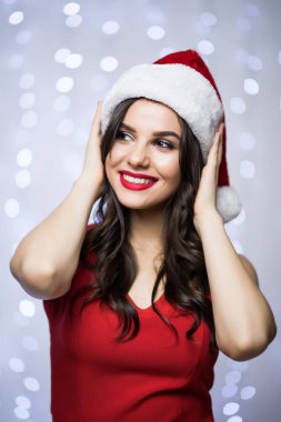 Noel Baba şapkası ve kırmızı elbise kadın portresi over head bokeh ışık arka plan üzerinde eller. Kış tatil Noel ve yeni yıl kavramı