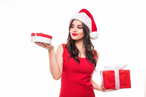 Joven chica de Navidad en vestidos rojos sosteniendo regalo en un equilibrio de manos de regalo sobre fondo blanco —  Fotos de Stock