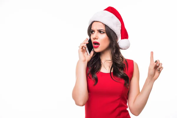 Щаслива мила дівчина з емоціями в капелюсі Санта розмовляє на мобільному телефоні на білому тлі — стокове фото