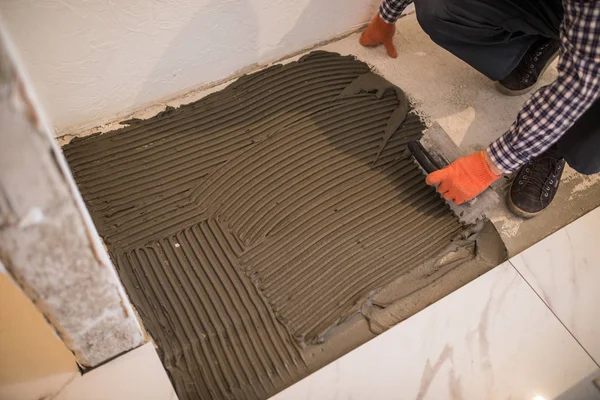 Укладання керамічної плитки. Намотування розчину на бетонну підлогу в підготовці до укладання плитки для білої підлоги . — стокове фото