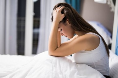 Depresyon gece evde yatağında olan kadın. Geceleri yatakta üzgün kadın