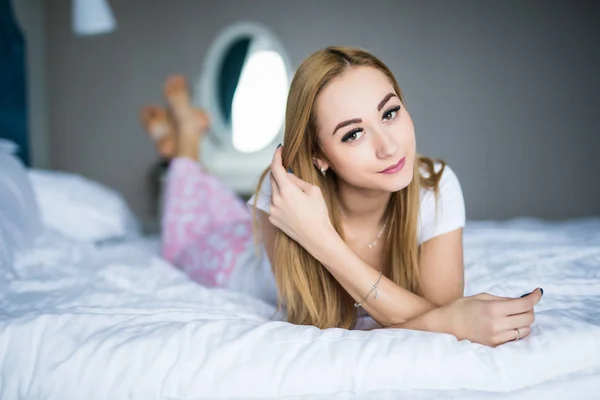 Jeune jolie femme couchée au lit à la maison — Photo