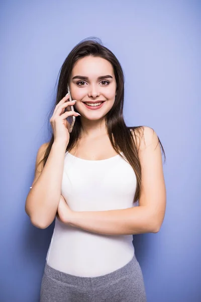 Belle jeune femme parlant par téléphone mobile aux rideaux à la maison — Photo