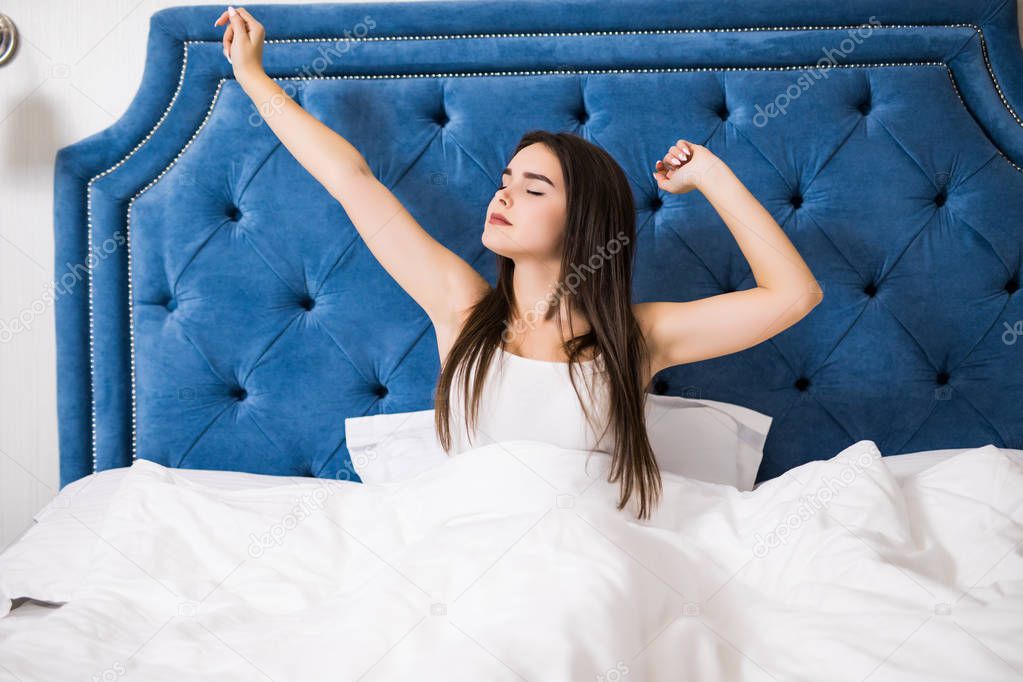 Woman stretching in bed after wake up in the morning