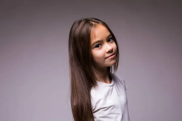 Egy szürke háttér elszigetelt mosolygó kifejezés kislány portréja — Stock Fotó